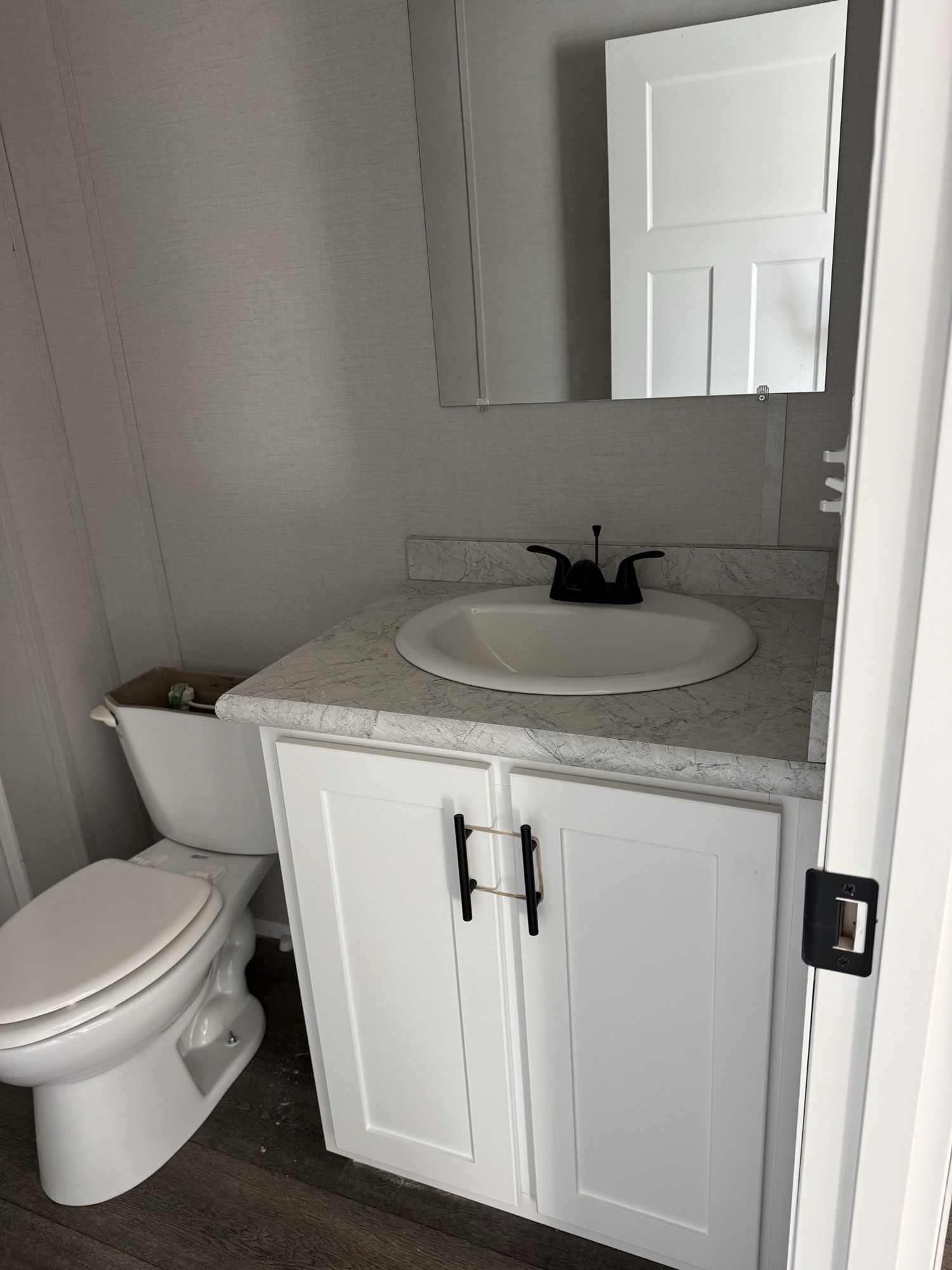 New manufactured home bathroom — Limestone community, Finger Lakes NY. Single vanity, framed mirror, matte-black fixtures.